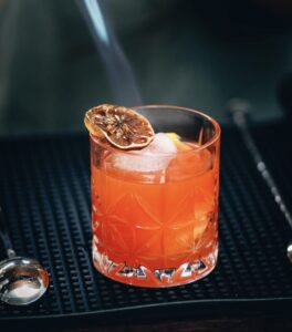 Hot Vodka Cranberry drink with dry orange on top. 