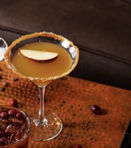 Caramel Apple Martini drink. Martini glass. Slide of Apple in cocktail. 